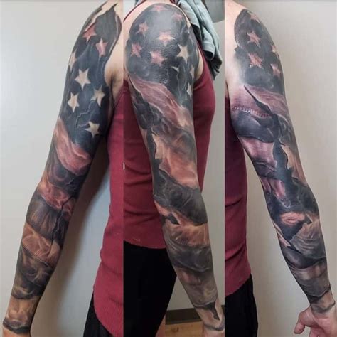 The picture above shows a magnificent realistic We The People tattoo with flag of the United States in black and grey ink etched on the wearers upper arm. . Black and white patriotic sleeve tattoos